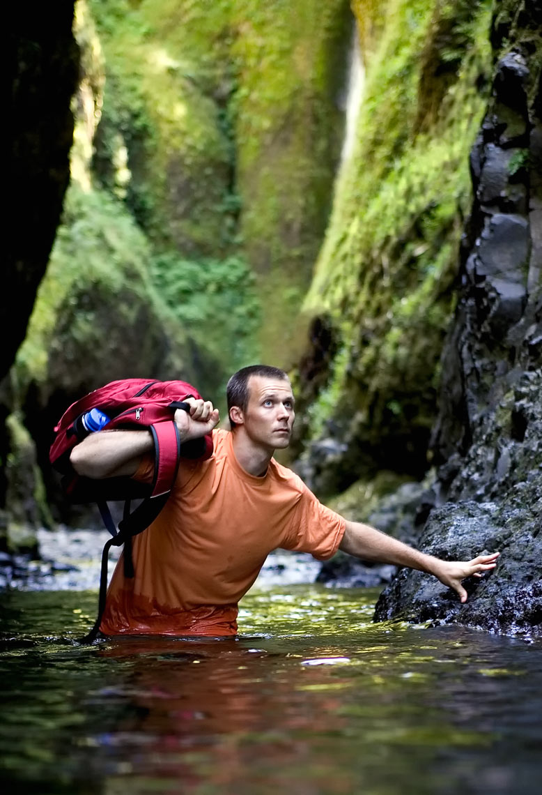 Advertising photography Portland - man walking waist deep through water in a gorge