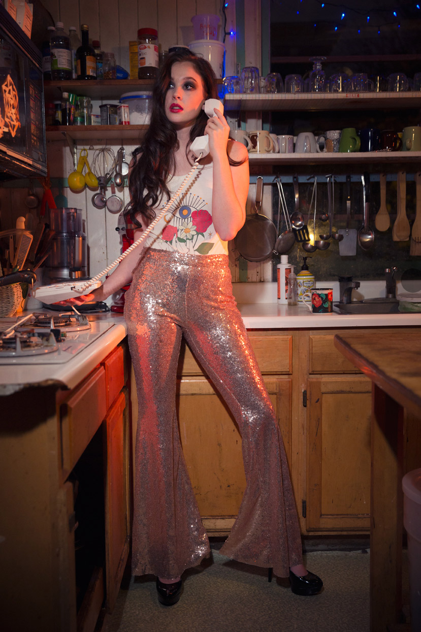 Fashion photography Portland - young woman in a kitchen holding a phone to her ear by Michael Schmitt