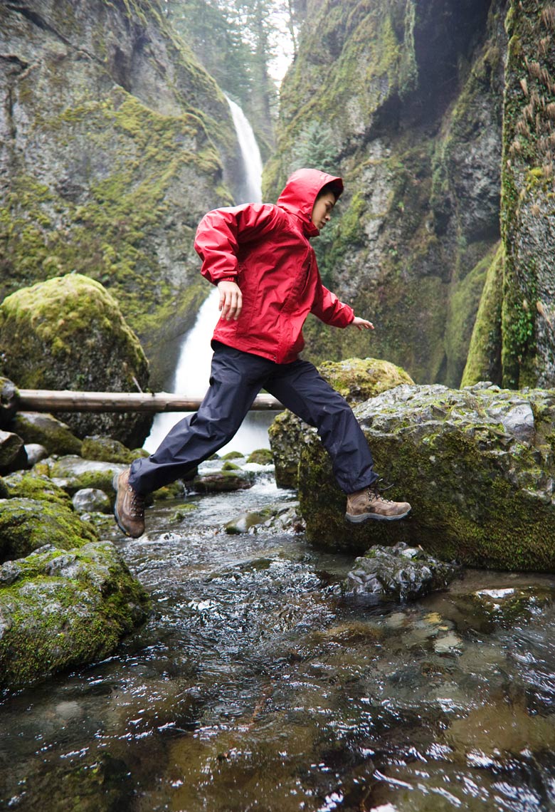 Advertising photographer Portland - athlete jumping over creek with a waterfall in the background for Columbia Sportswear