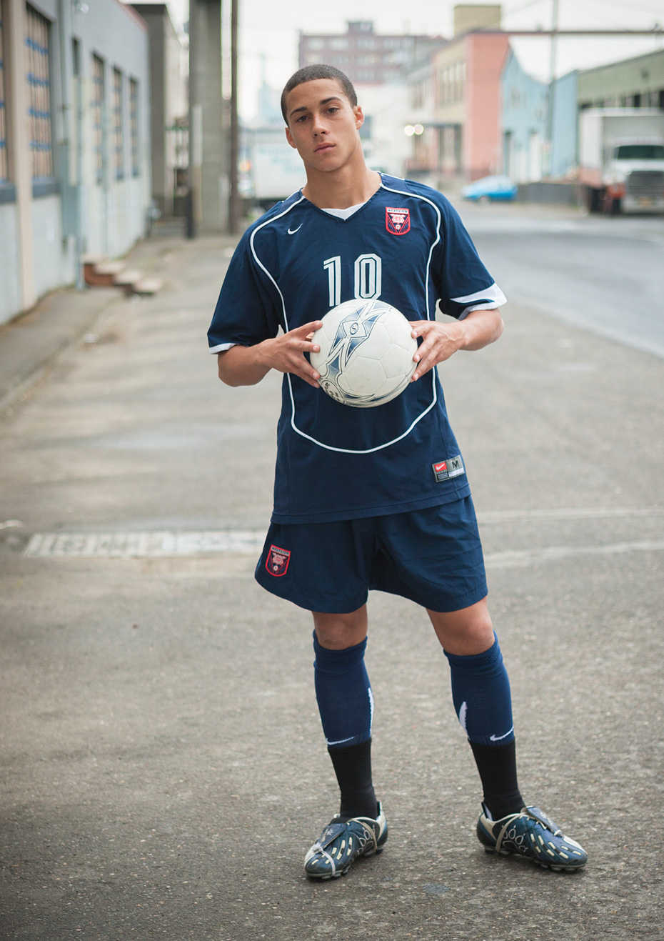 Commercial photographer Portland - soccer player holding ball in urban street