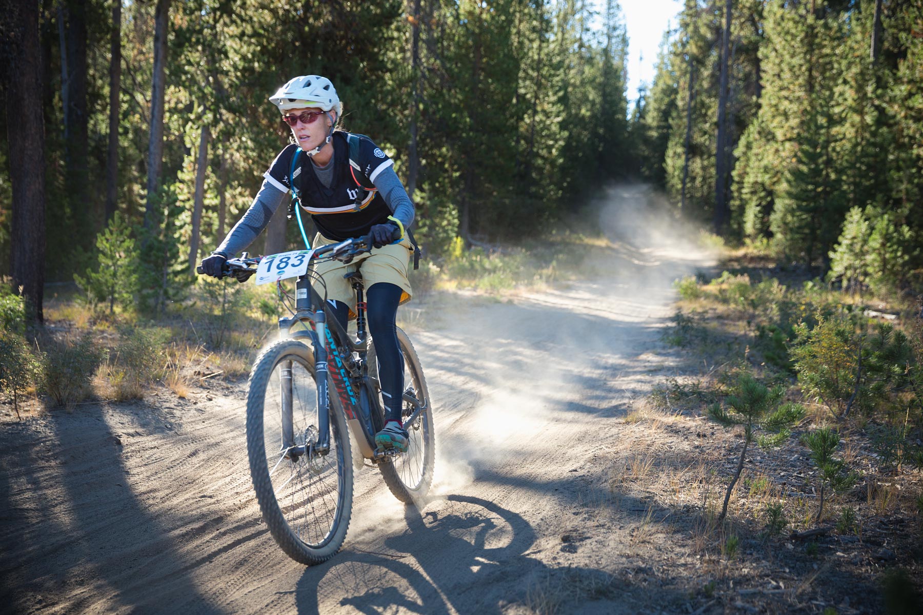 Editorial photographer documenting woman in a mountain bike race  going fast downhill.