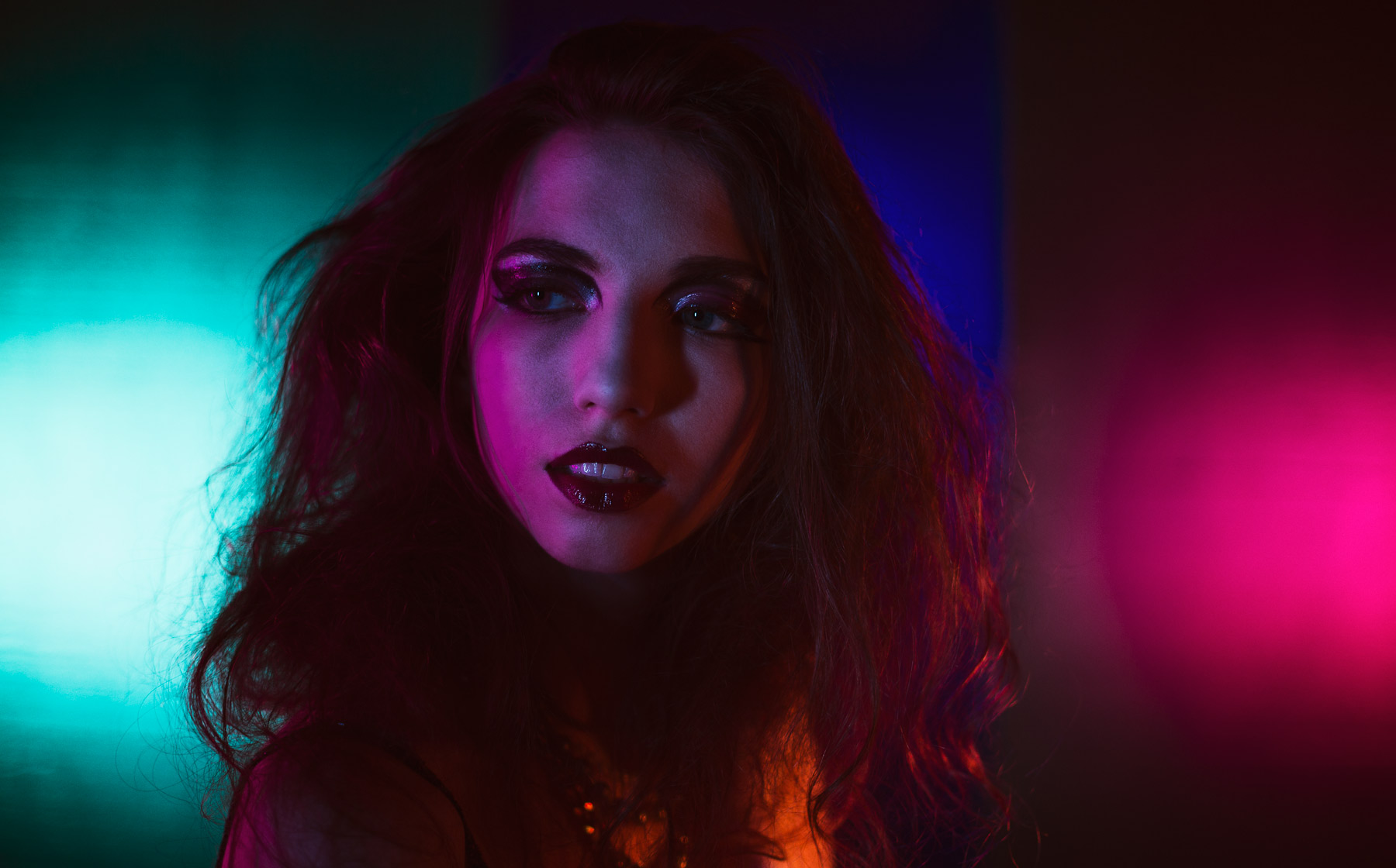 Portrait of woman surrounded with purple, blue, and magenta colors.