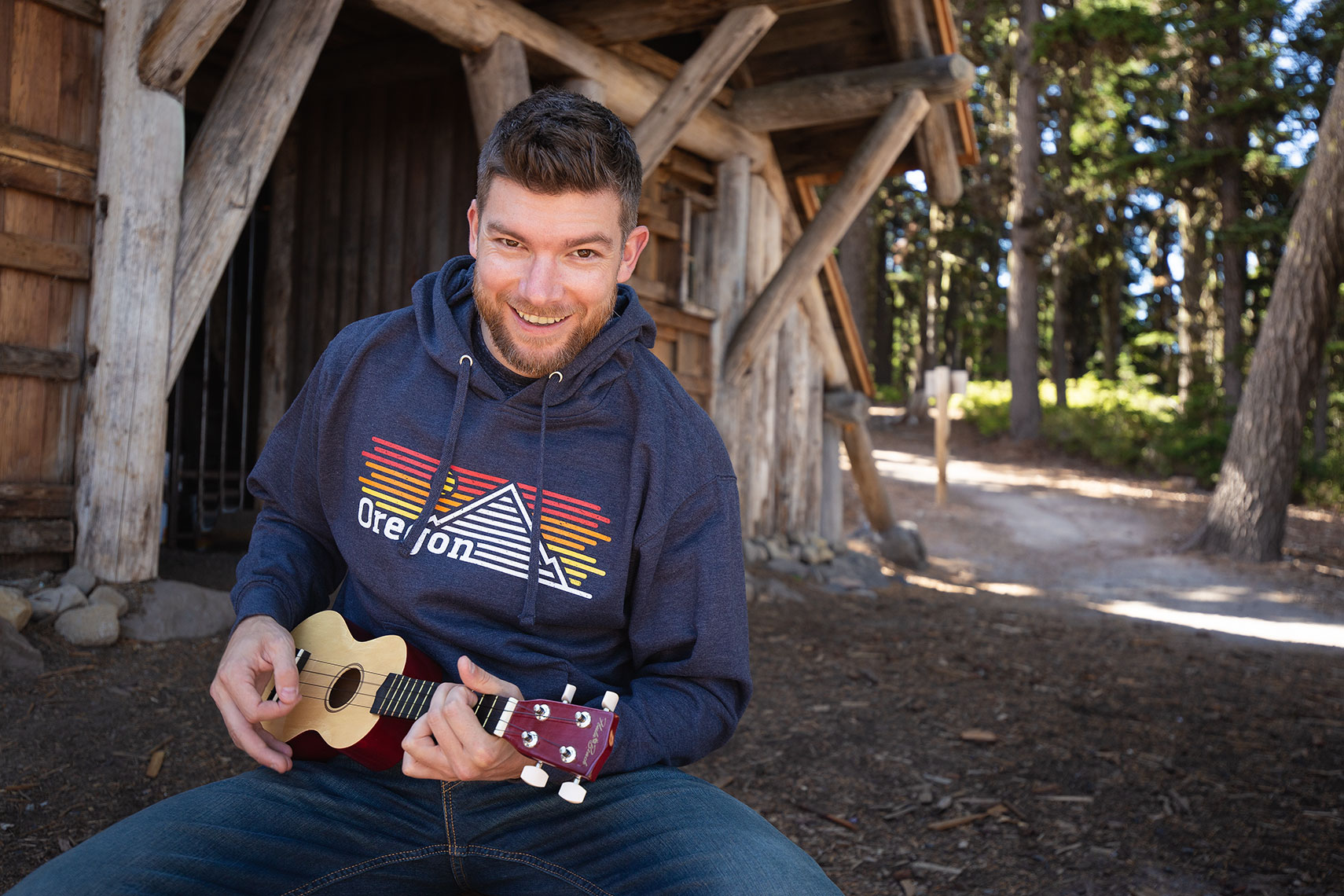 Advertising photography Portland - man with ukulele next to cabin