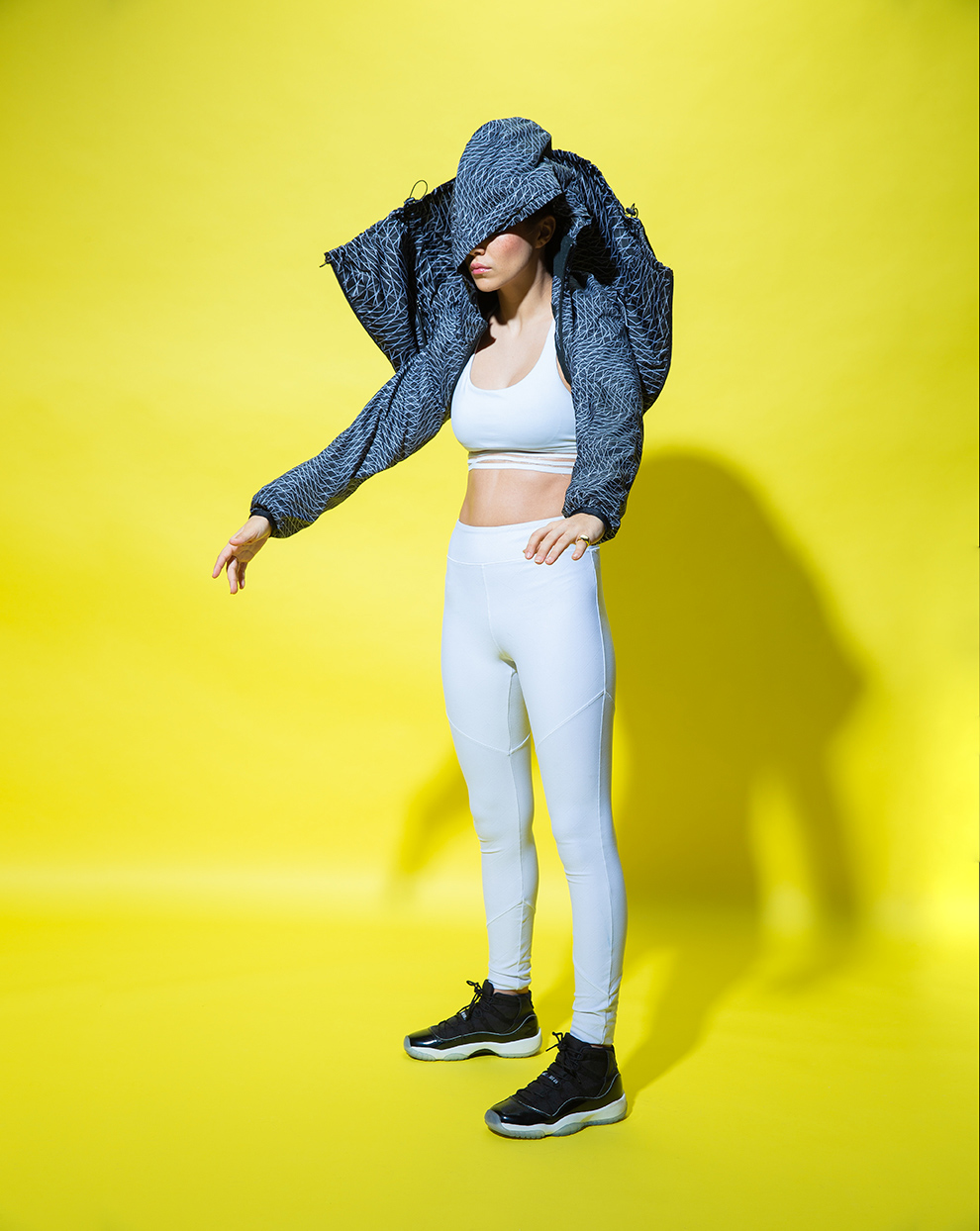 Portland Commercial Photography - athlete in Nike gear  hidden by jacket hood on a yellow background
