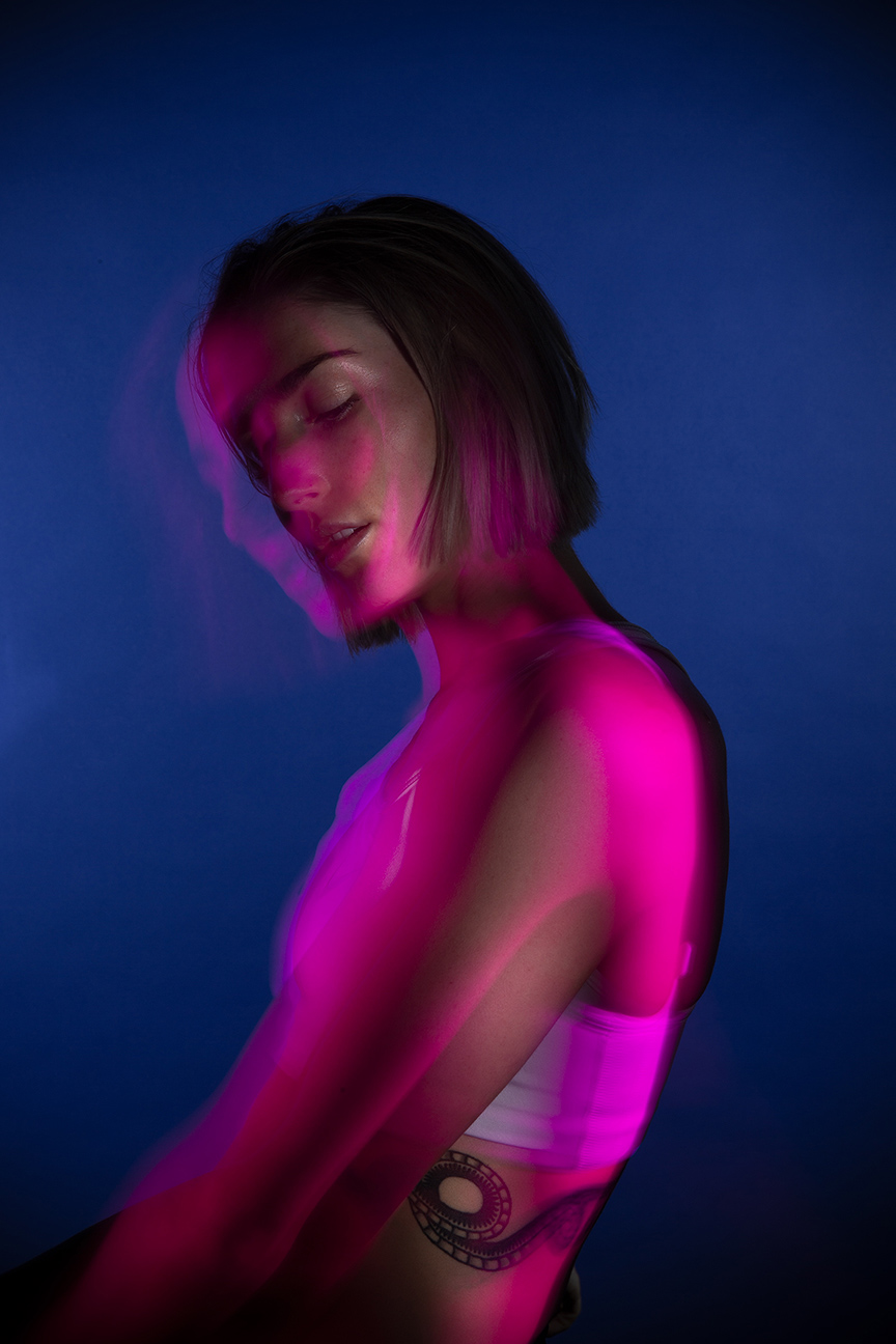 Editorial photography Portland - woman surrounded by purple light on blue background